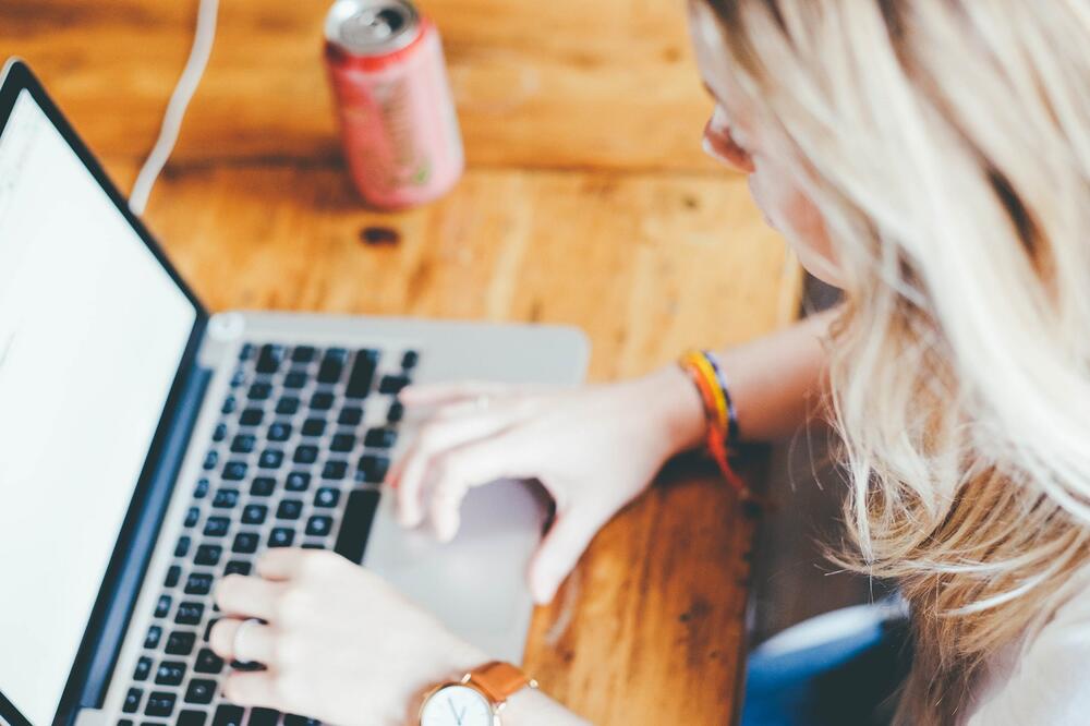 Woman with blonde hair shopping on a laptop